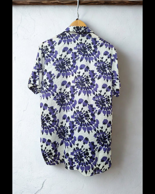 Blue floral patterned shirt hanging on a white wall