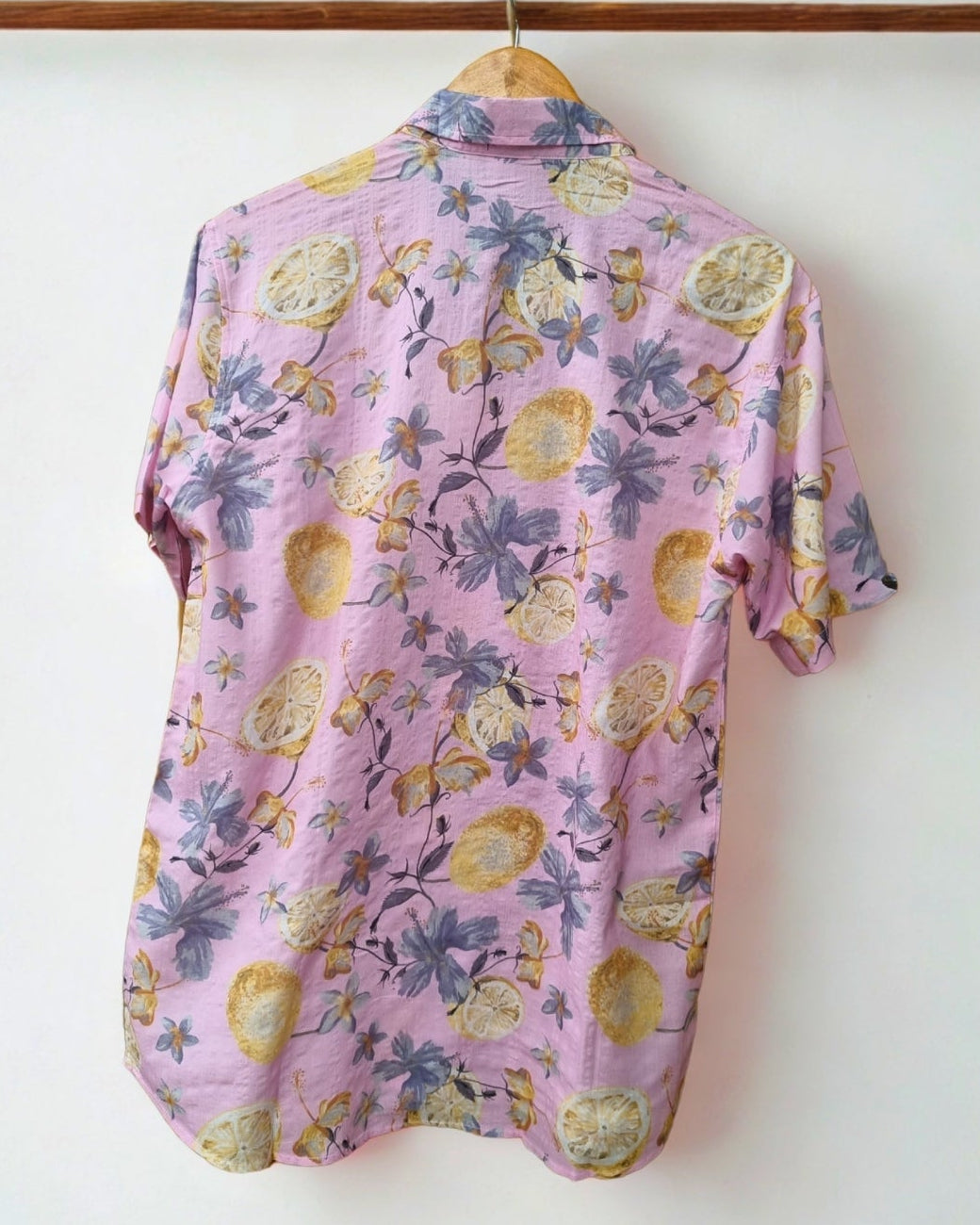 Floral-patterned shirt on a hanger with a visible brand logo against a white background