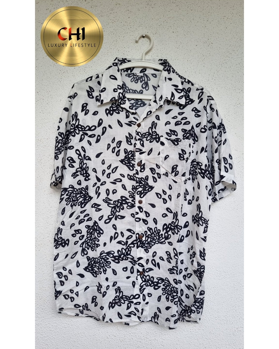 White shirt with black floral pattern on a hanger, with 'CHI' brand logo.