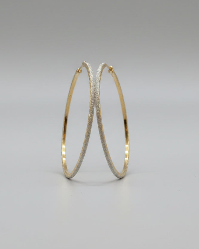 Gold hoop earrings on a card with a soft background