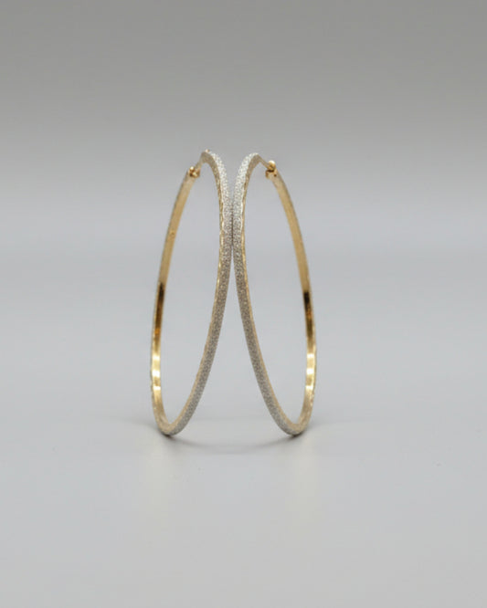 Gold hoop earrings on a card with a soft background