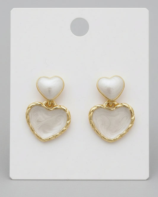 Heart-shaped earrings with gold accents on a white card.