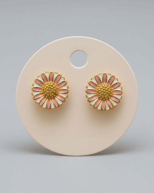 Gold and pink flower-shaped earrings on a beige display card.