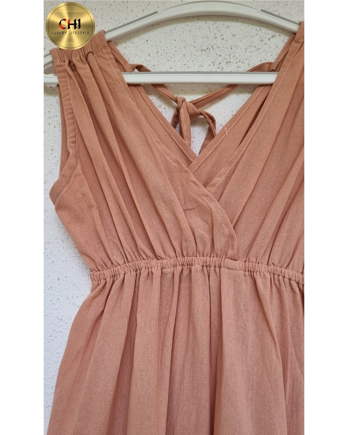 Rose-colored dress on a hanger against a white background