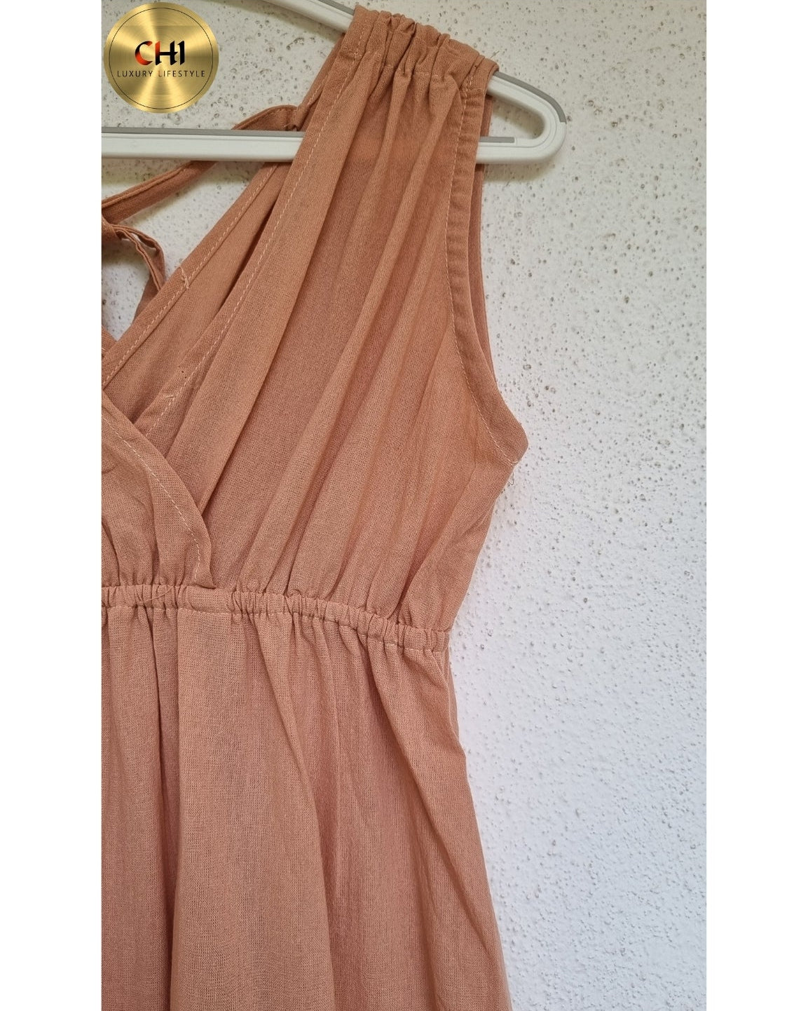 Brown sleeveless dress on a hanger with a white background