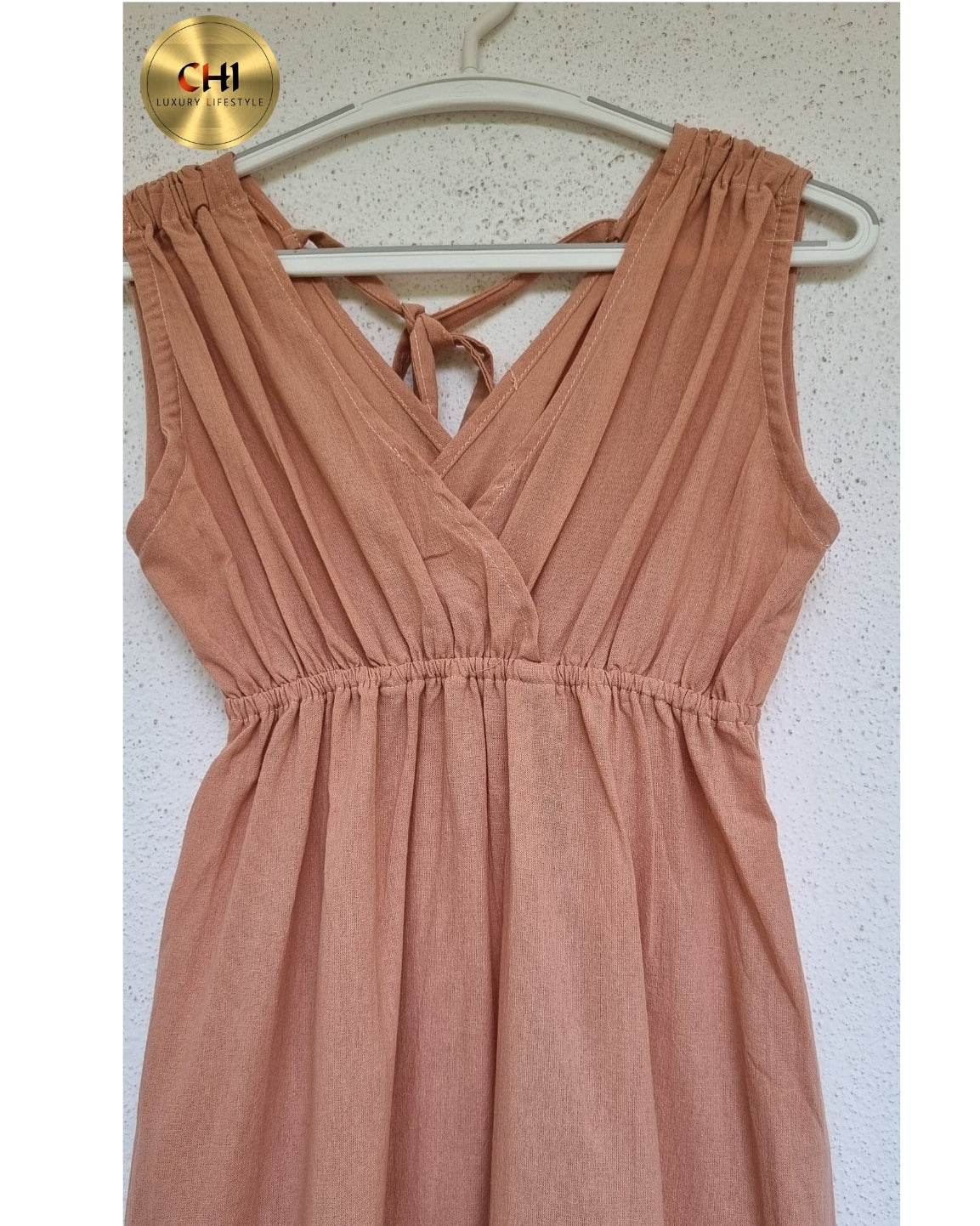 Brown dress on a hanger against a white background