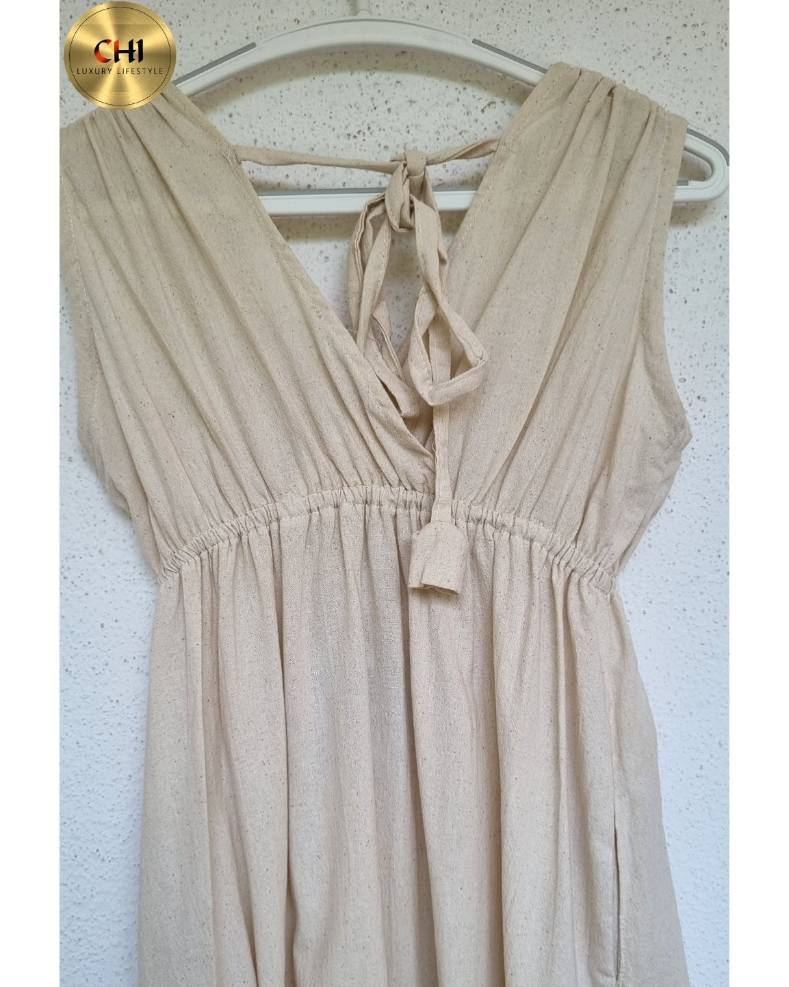 Beige dress on a hanger against a white background