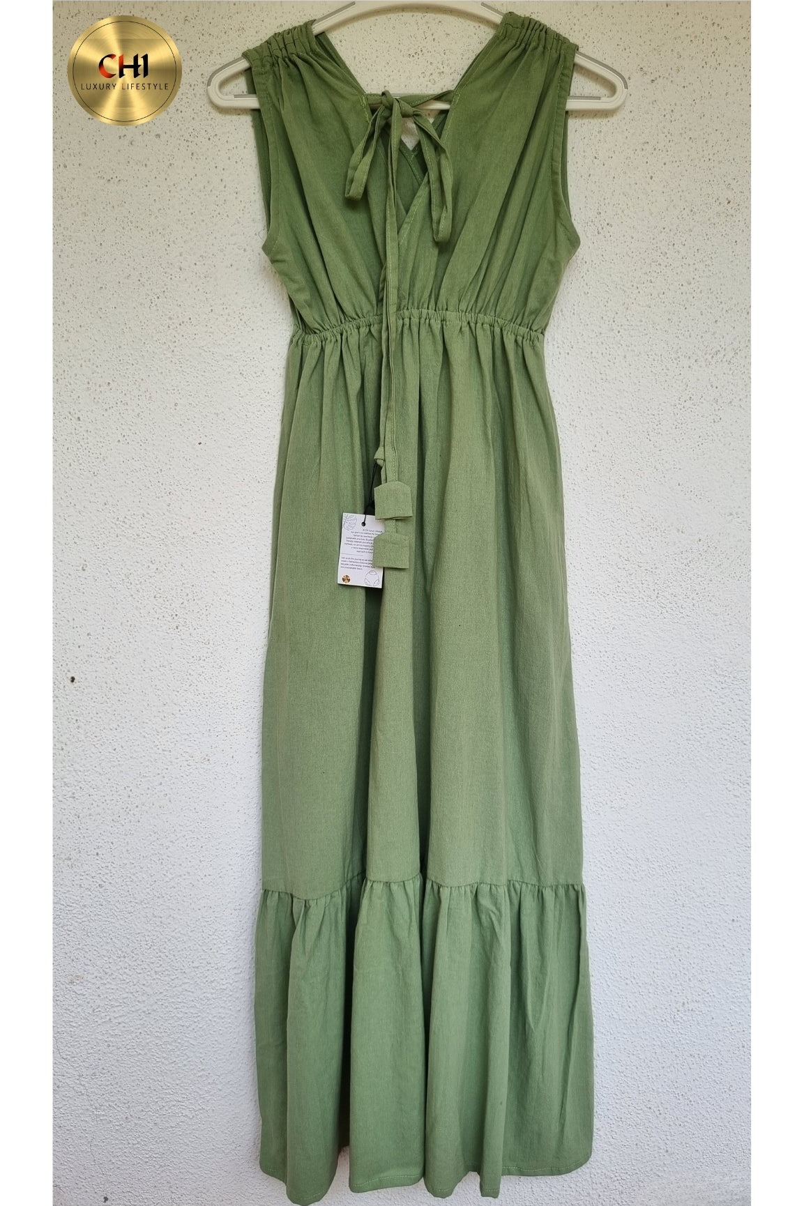 Green dress on a hanger against a white background