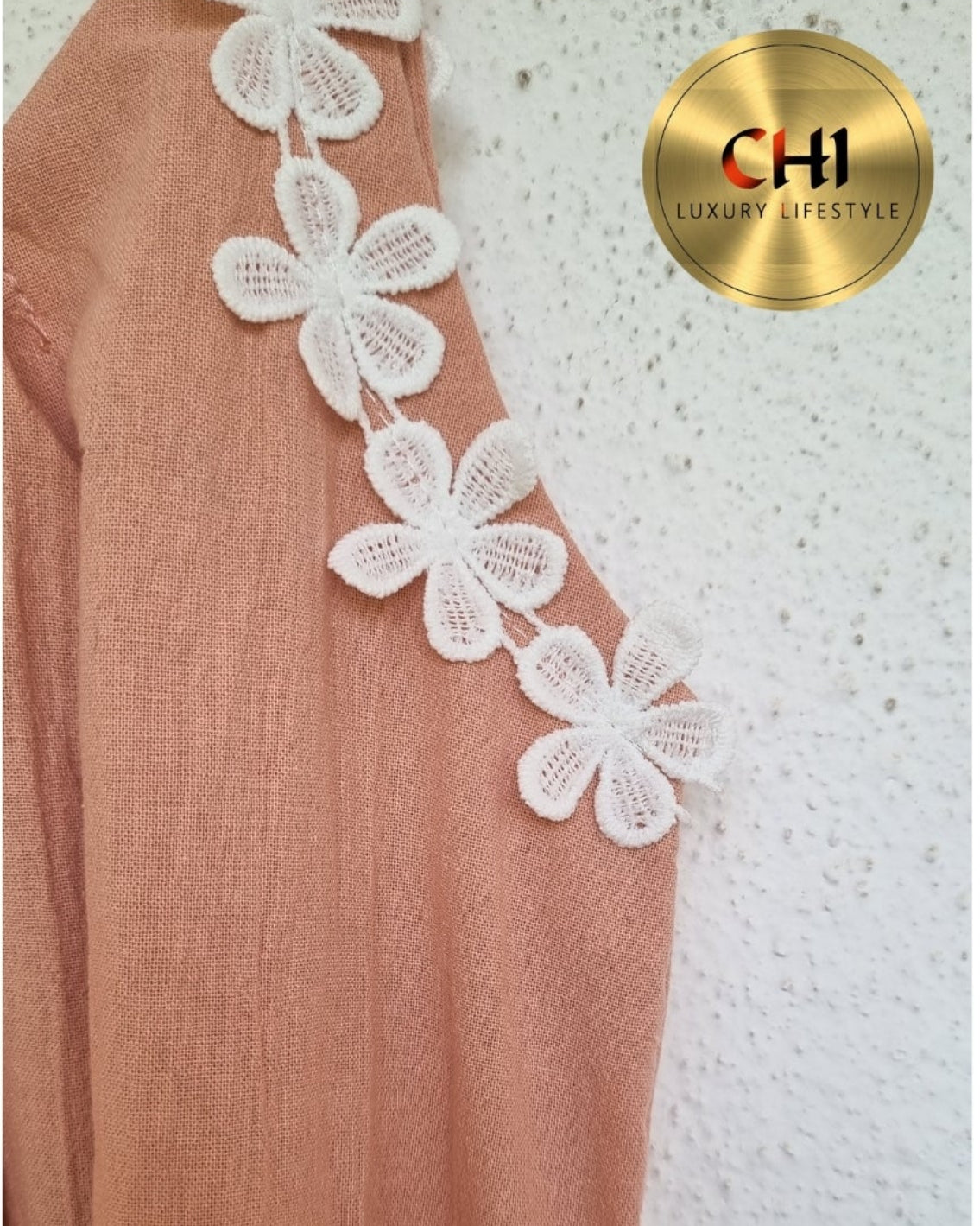 Brown garment with white floral lace details on a textured white background, featuring the CHI logo.