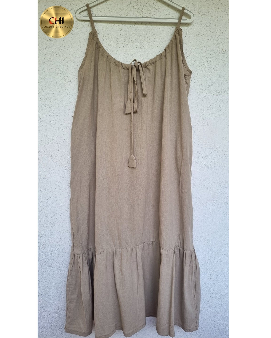 Beige dress on a hanger against a white background