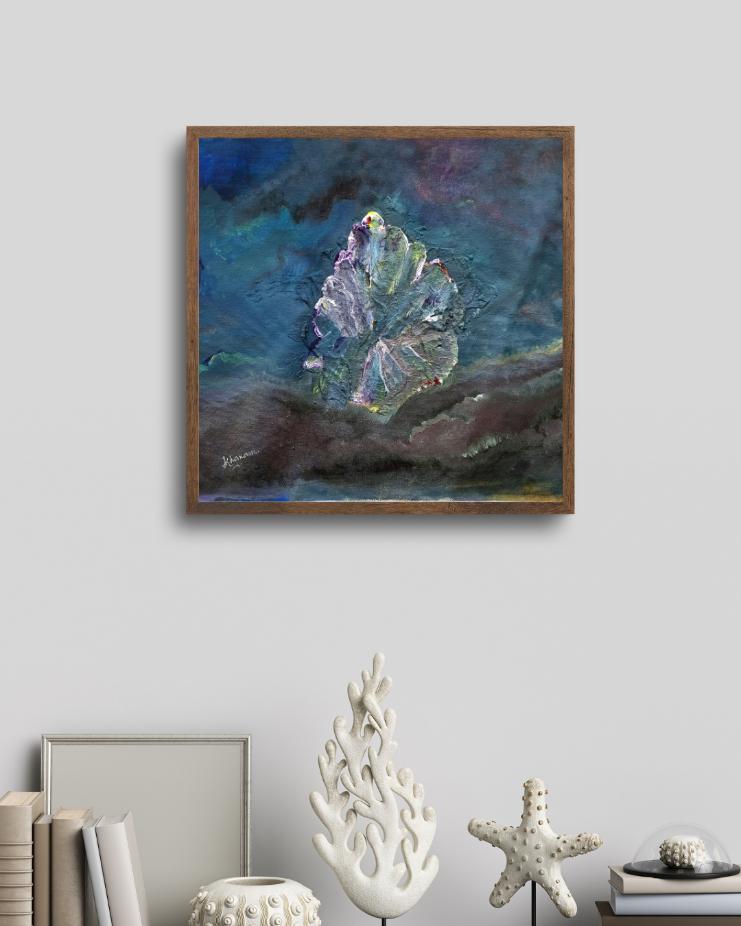 Framed abstract painting on a wall with decorative items below