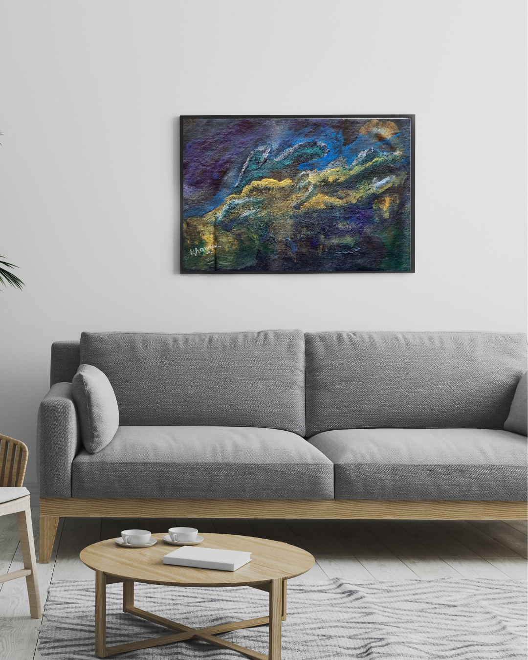 Living room with a gray sofa, round wooden coffee table, and abstract painting on the wall.