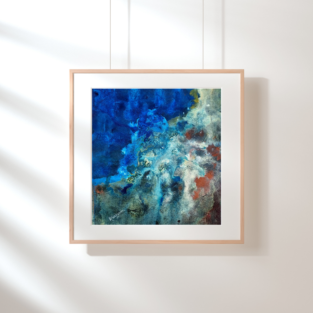 Framed abstract artwork with blue and white tones on a white wall