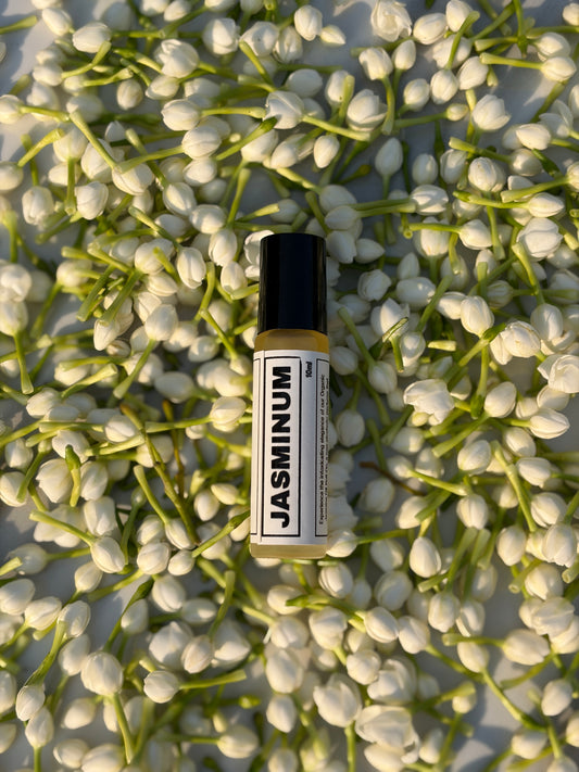 Small bottle labeled 'Jasminum' on a bed of jasmine flowers
